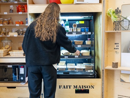 Étudiante choisissant un sandwich dans un distributeur de la cafétéria du campus de Rennes de l’école de commerce INSEEC